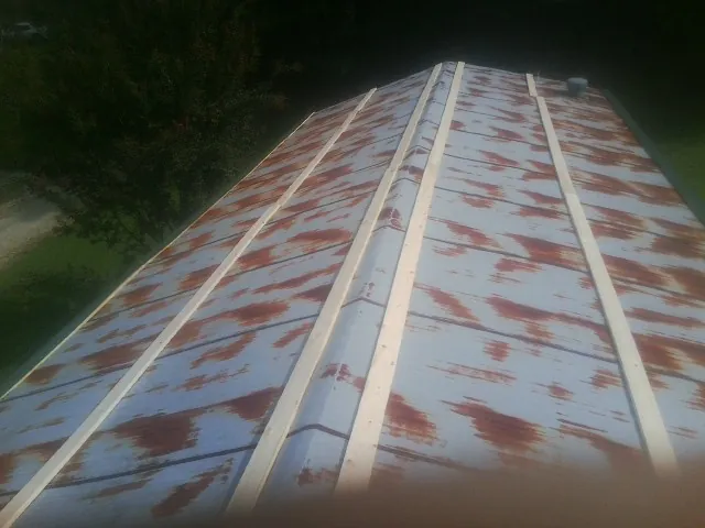 Rusted metal roof panels with new wood purlins before replacement — Storm Damage Roof Repair in Prosperity by Roofing Brothers