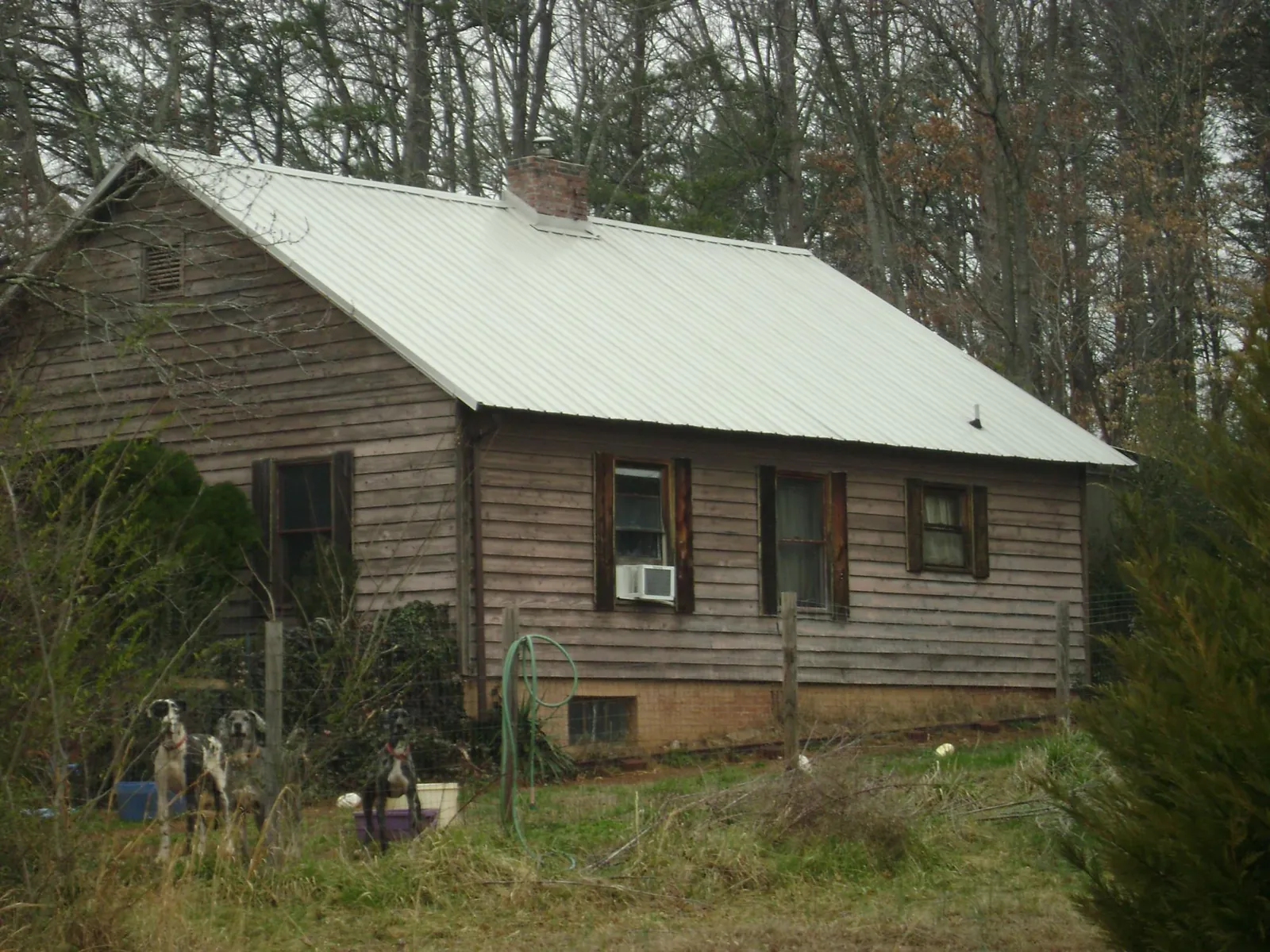 White metal roof on an old wood sided farmhouse, from a Metal Roof Installation job in Prosperity
